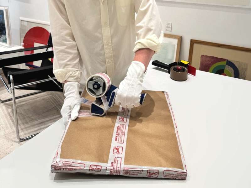 Colis d’œuvre d’art terminé, fermé par une bande de garantie inviolable rouge et blanche