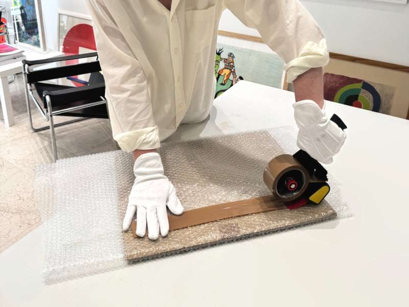 Colis d’œuvre d’art entièrement enveloppé de papier bulle et fermé au ruban adhésif